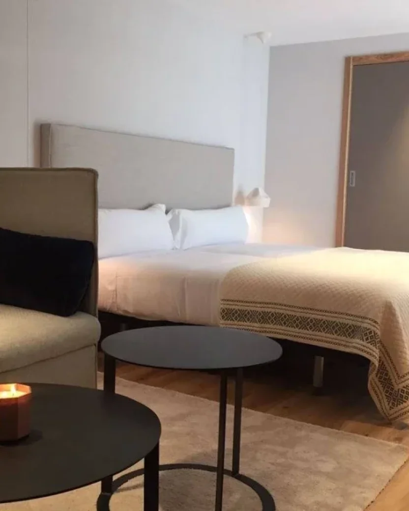Moderne lichte kamer met groot bed en zithoek.