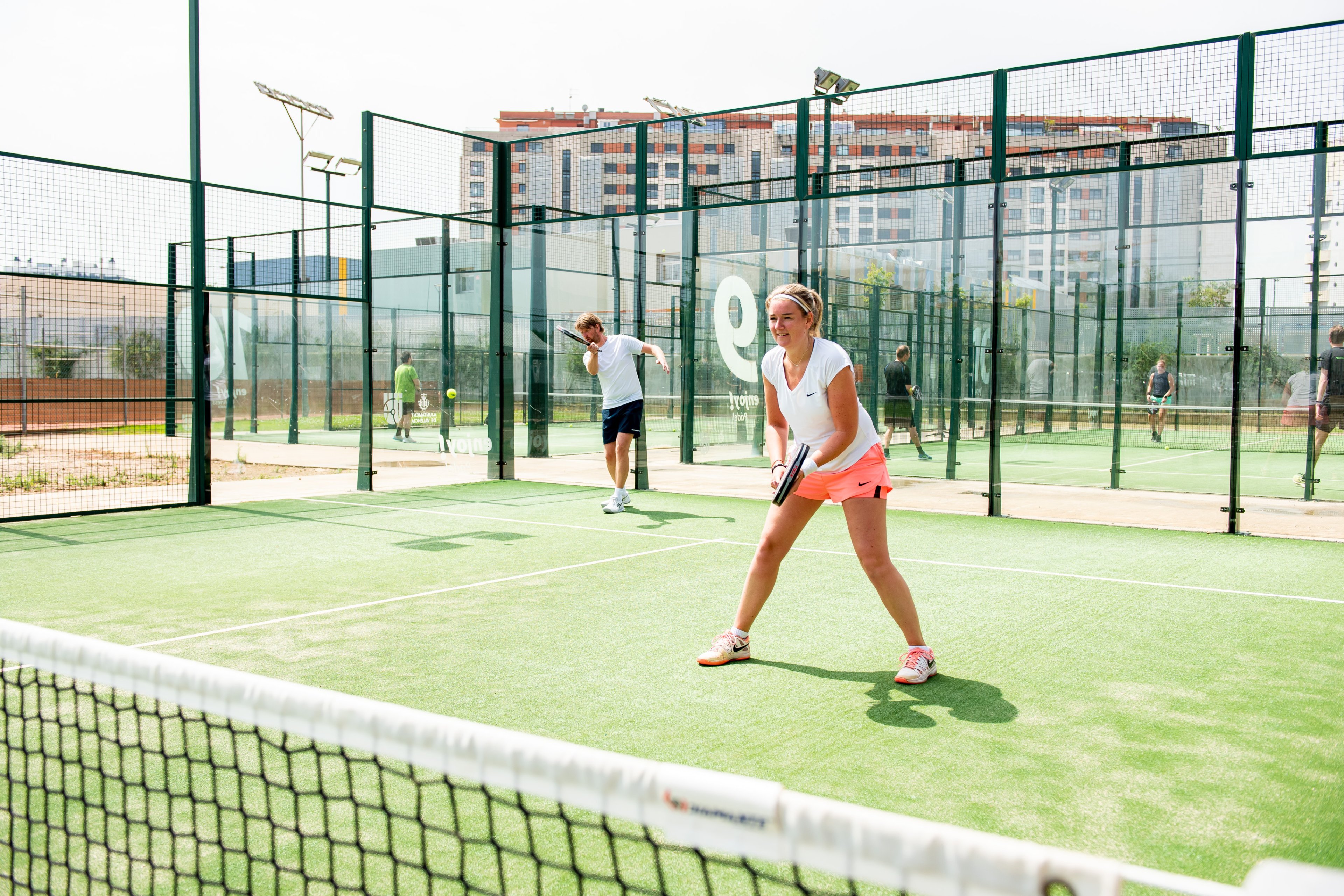 Padellers in actie buiten op de padelbaan.
