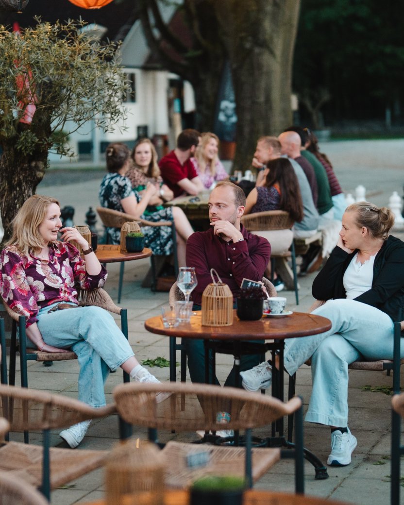 Reisgenoten zitten samen op het terras en raken met elkaar in gesprek.