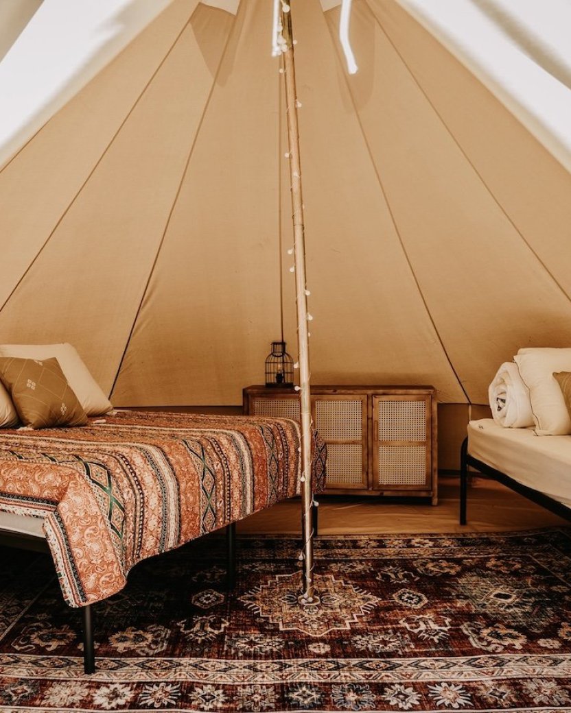 Sfeervolle glampingtent met twee bedden.