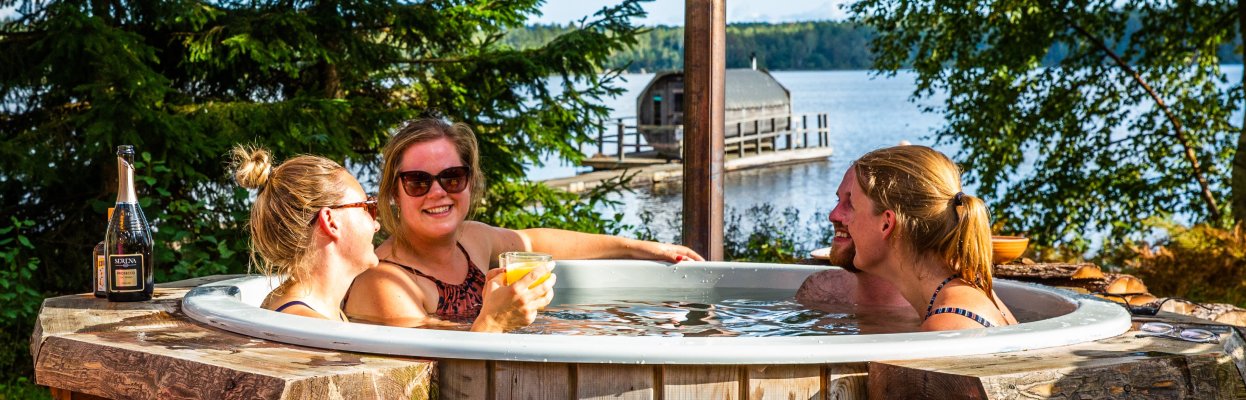 Reisgenoten ontspannen samen buiten in de zon in de jacuzzi tussen het groen.