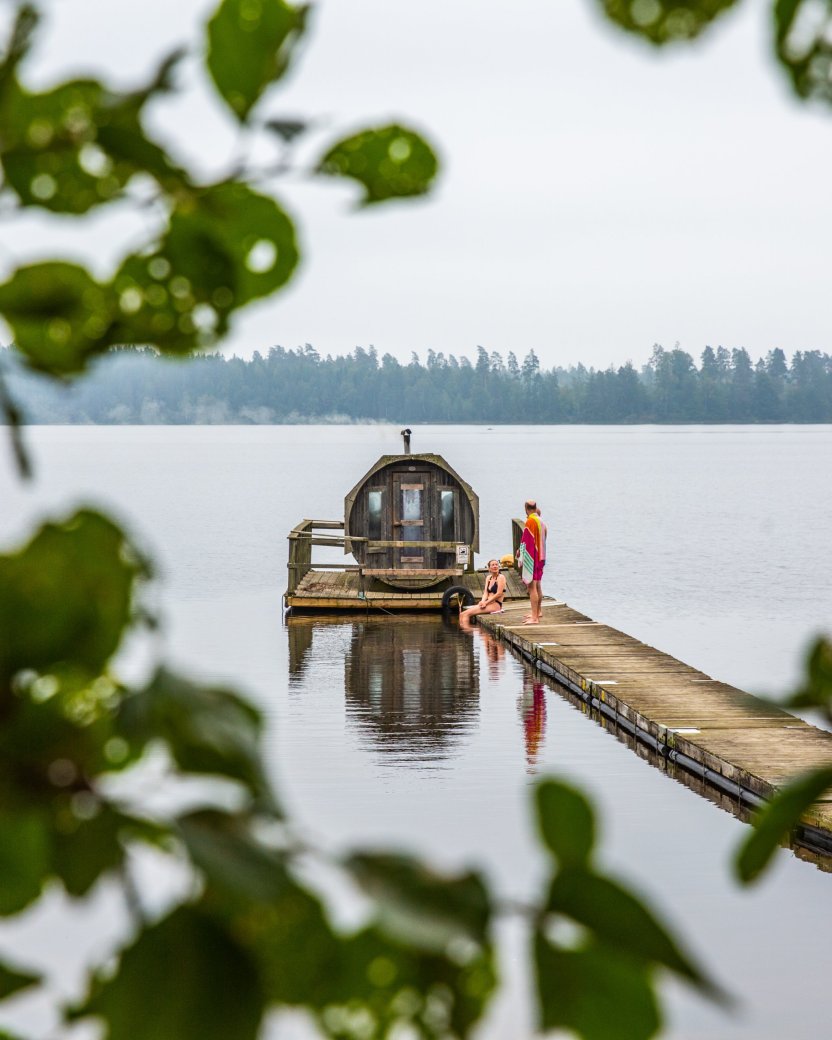 Twee reisgenoten ontspannen op de steiger bij de sauna op het meer.