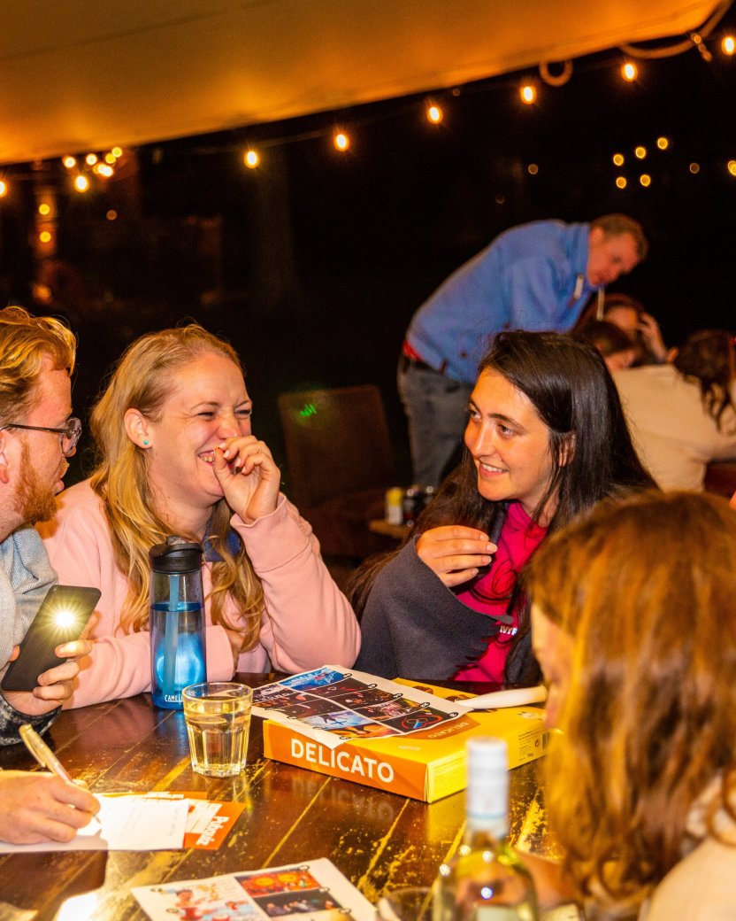 Reisgenoten spelen een spel buiten onder de sfeerverlichting in de avond.