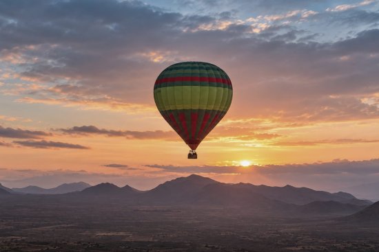 Luchtballonvaart tijdens zonsopgang.