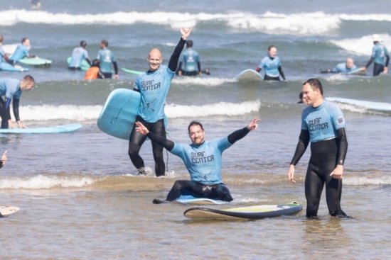 Reisgenoten poseren in het water tijdens de surfles in Ericeira.