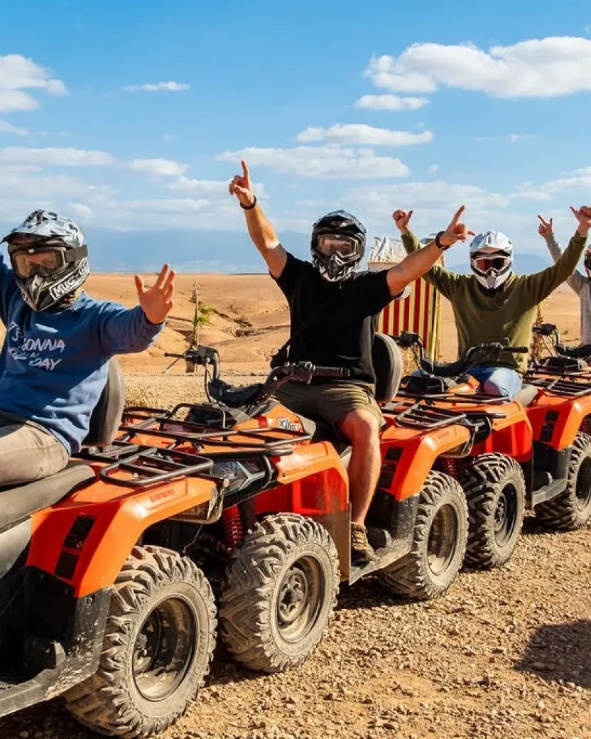 Reisgenoten poseren op quads in de woestijn.
