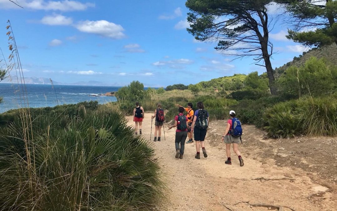 Reisgenoten wandelen langs de kust in Mallorca.