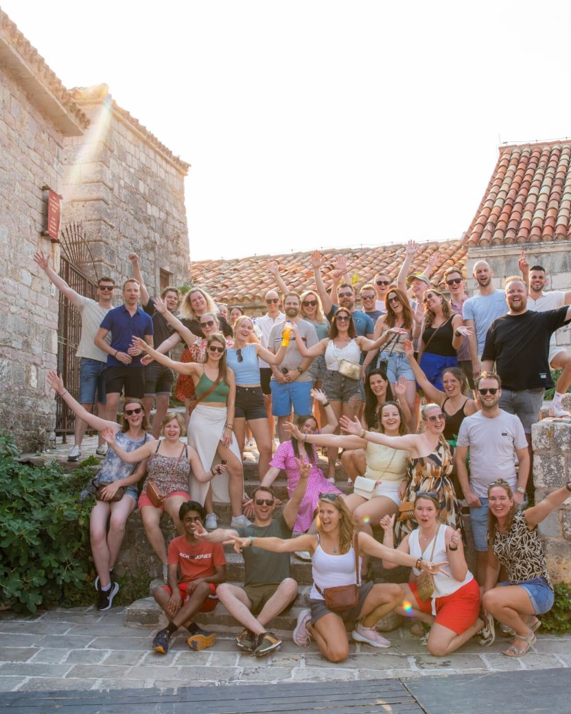 Groep reisgenoten poseert in een dorp in montenegro.