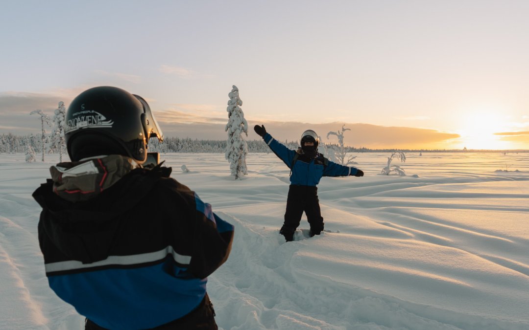 Reisgenoten maken foto's in de hoge sneeuw in Lapland.