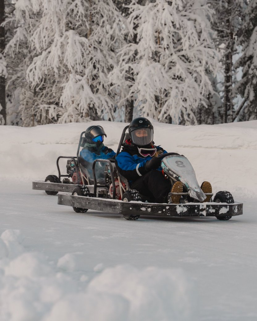Reisgenoten op sneeuwkarts in het besneeuwde landschap.