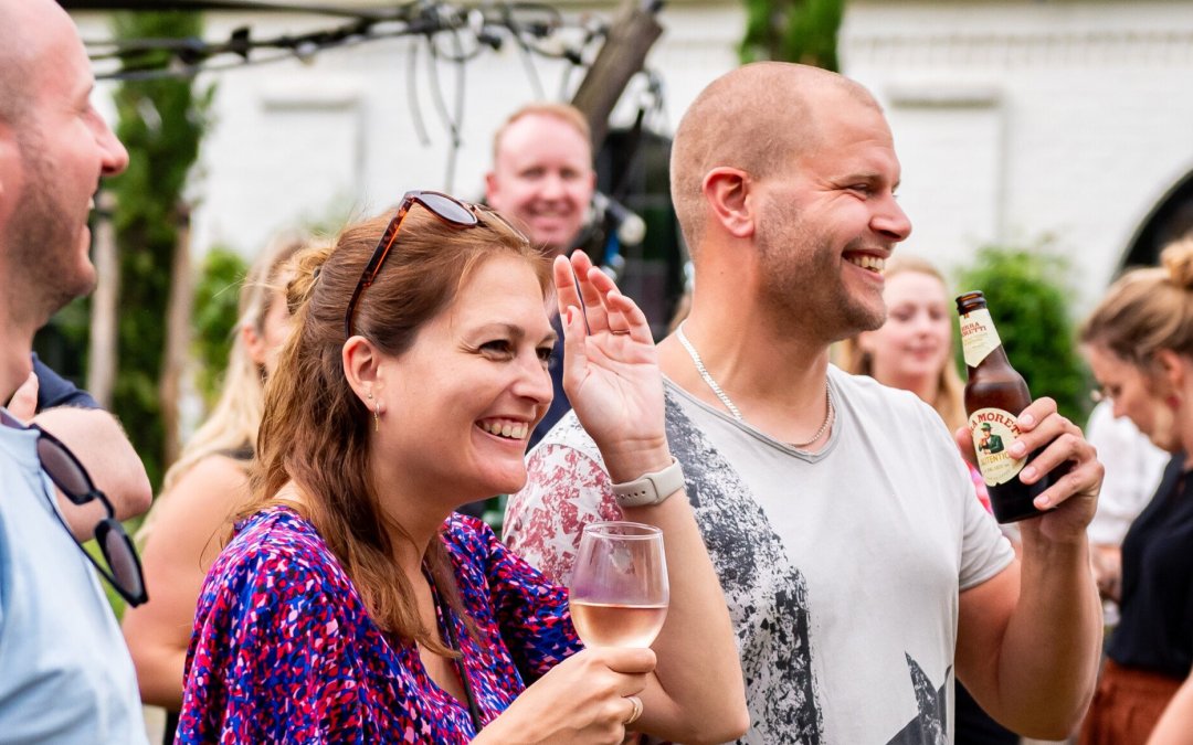 Reisgenoten lachen met elkaar tijdens een borrel.