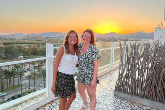 Marcella poseert samen met Anouk op het balkon met zonsondergang op het achtergrond.
