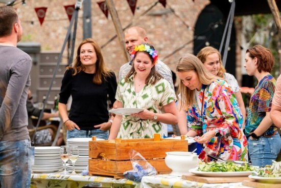 Marcella staat met reisgenoten bij het buffet.