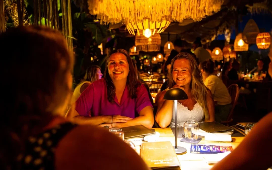 Twee reisgenoten lachen met elkaar tijdens het diner in Kreta.