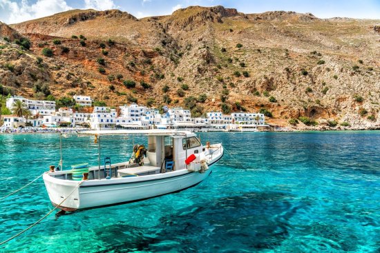 Boot op het helderblauwe water voor de kust in kreta.
