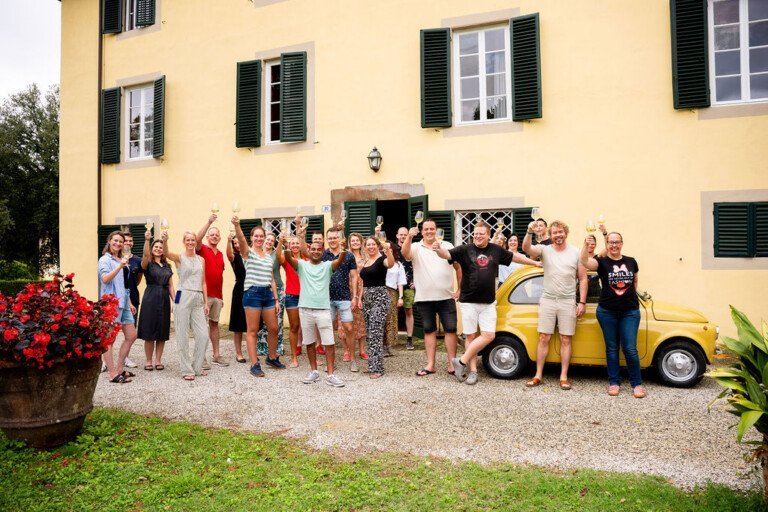 Reisgenoten proosten met wijn voor de Toscaanse Villa.