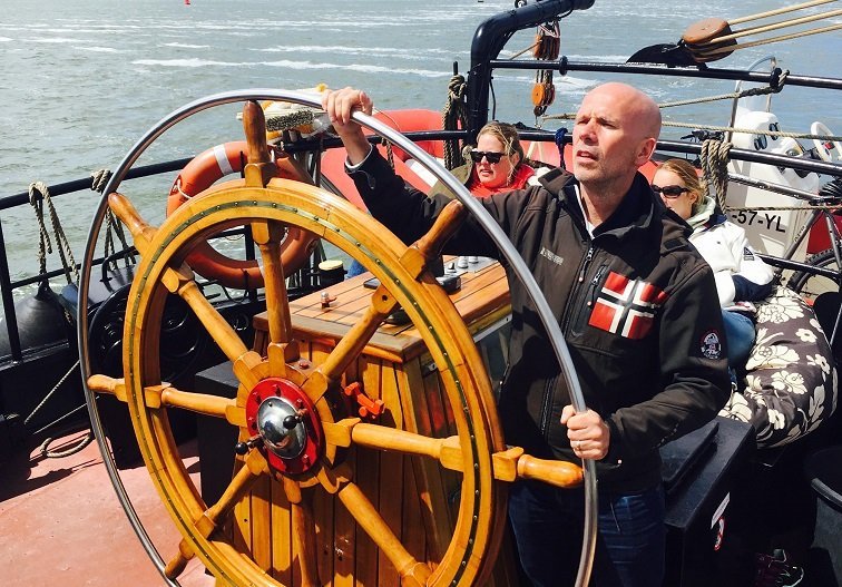 Oprichter Harold aan het stuur op een boot.