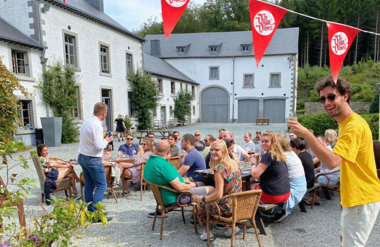 Reisgenoten zitten buiten op het terras bij villa Manoir.