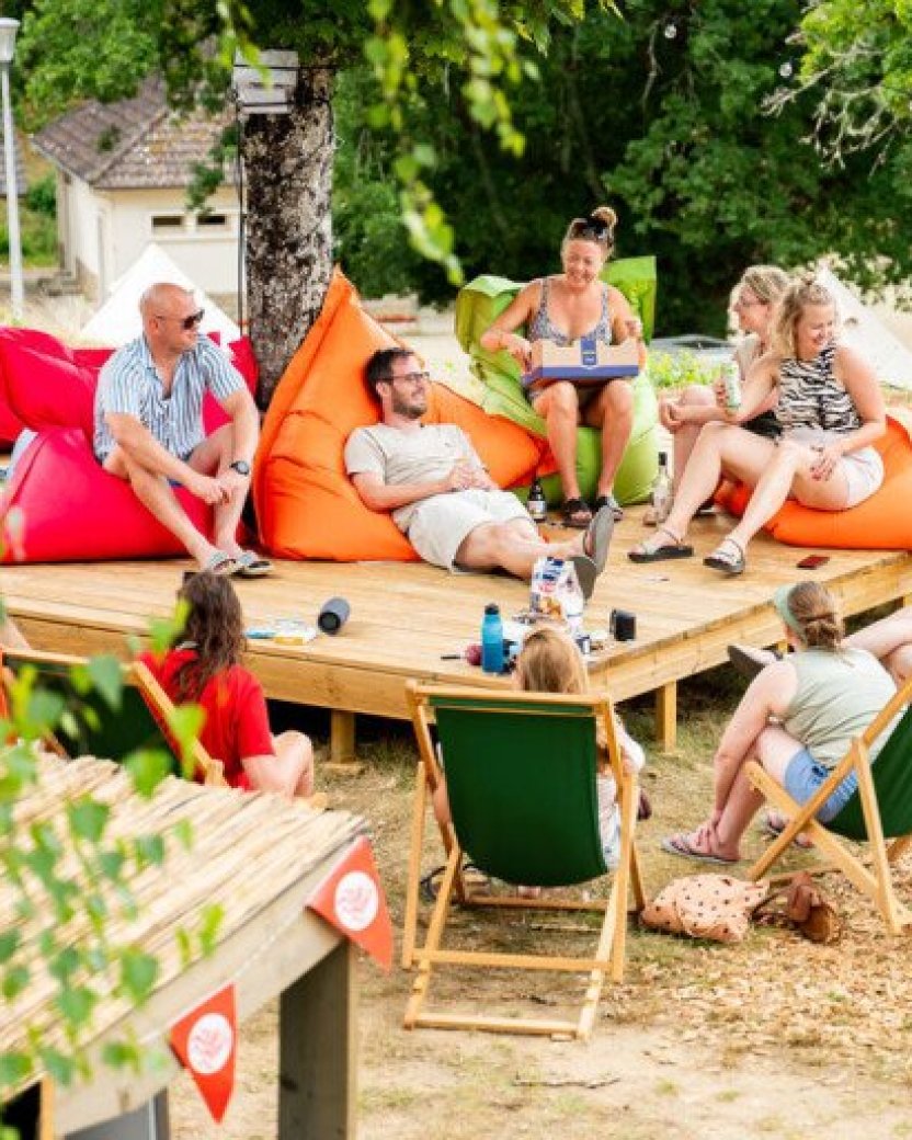 Reisgenoten ontspannen samen in de stoelen en zitzakken op de camping in Frankrijk.