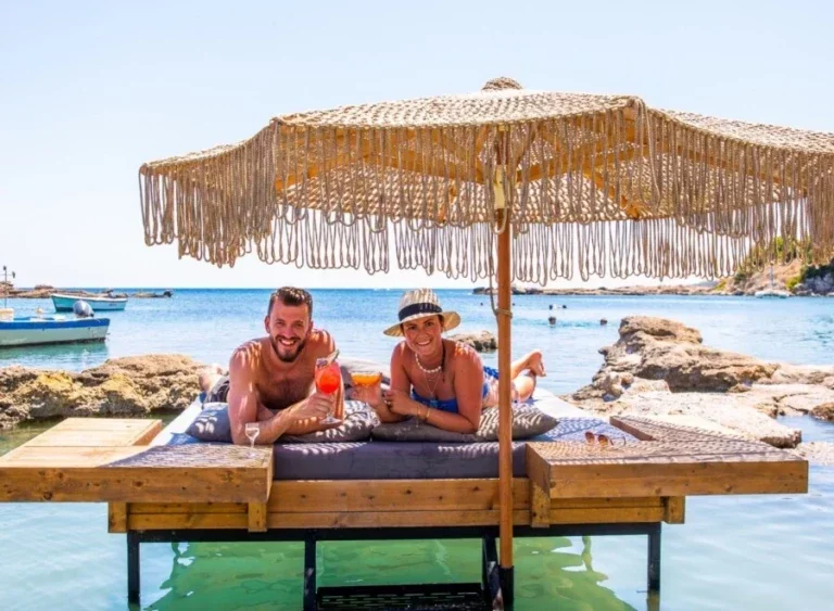 Twee reisgenoten proosten met een drankje op het strand in Gran Canaria.