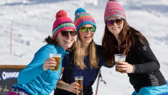 Wintersporters tijdens een borrel op de piste.