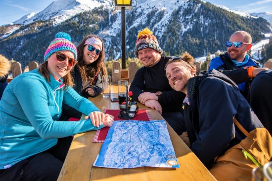 Wintersporters op het terras aan de piste tijdens de lunch.