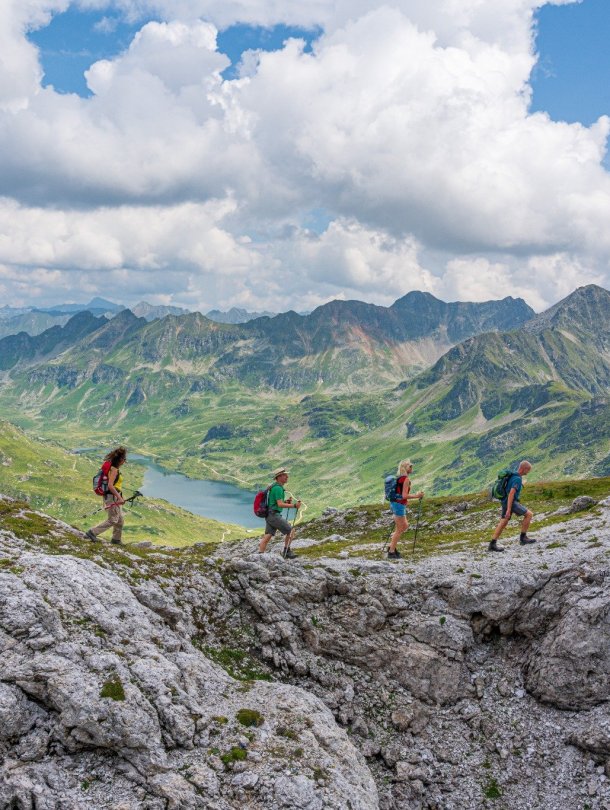 Reizigers wandelen over de top van de berg met berglandschap op het achtergrond.