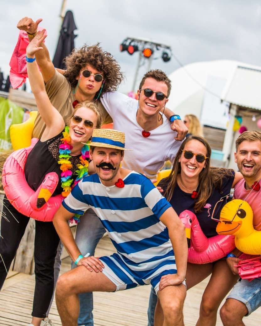 Reisgenoten poseren voor de foto tijdens het strandfeest.