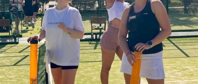 Reisgenoten poseren voor een foto op de padelbaan in Mallorca.