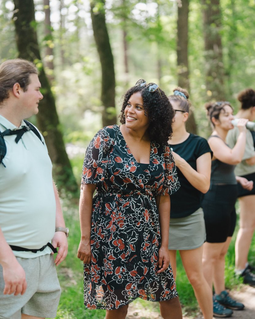 Reisgenoten kletsen met elkaar tijdens de wandeling in het bos.