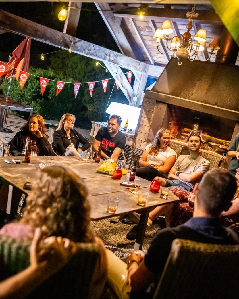 Reisgenoten kletsen met elkaar buiten in de avond.