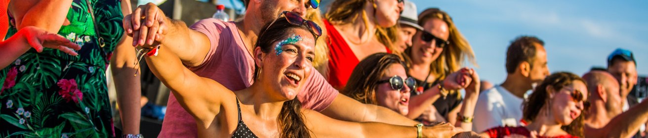 Reisgenoten feesten met elkaar op de beachparty.